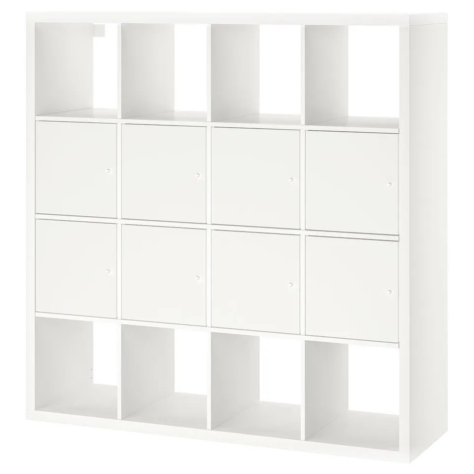 A white ikea KALLAX shelving unit with a mix of open and closed compartments. Its rectangular, with multiple cube-shaped sections for storage.