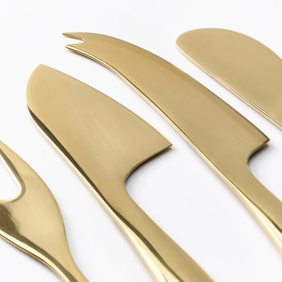 Three stainless steel serving utensils: fork, knife, spatula.