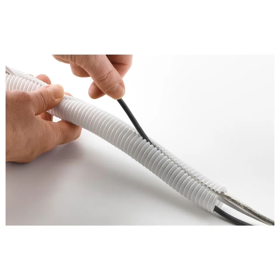 A hand is shown inserting a black cable into a white, spiral cable tidy. The tidy organises cables, keeping them neat and tidy.
