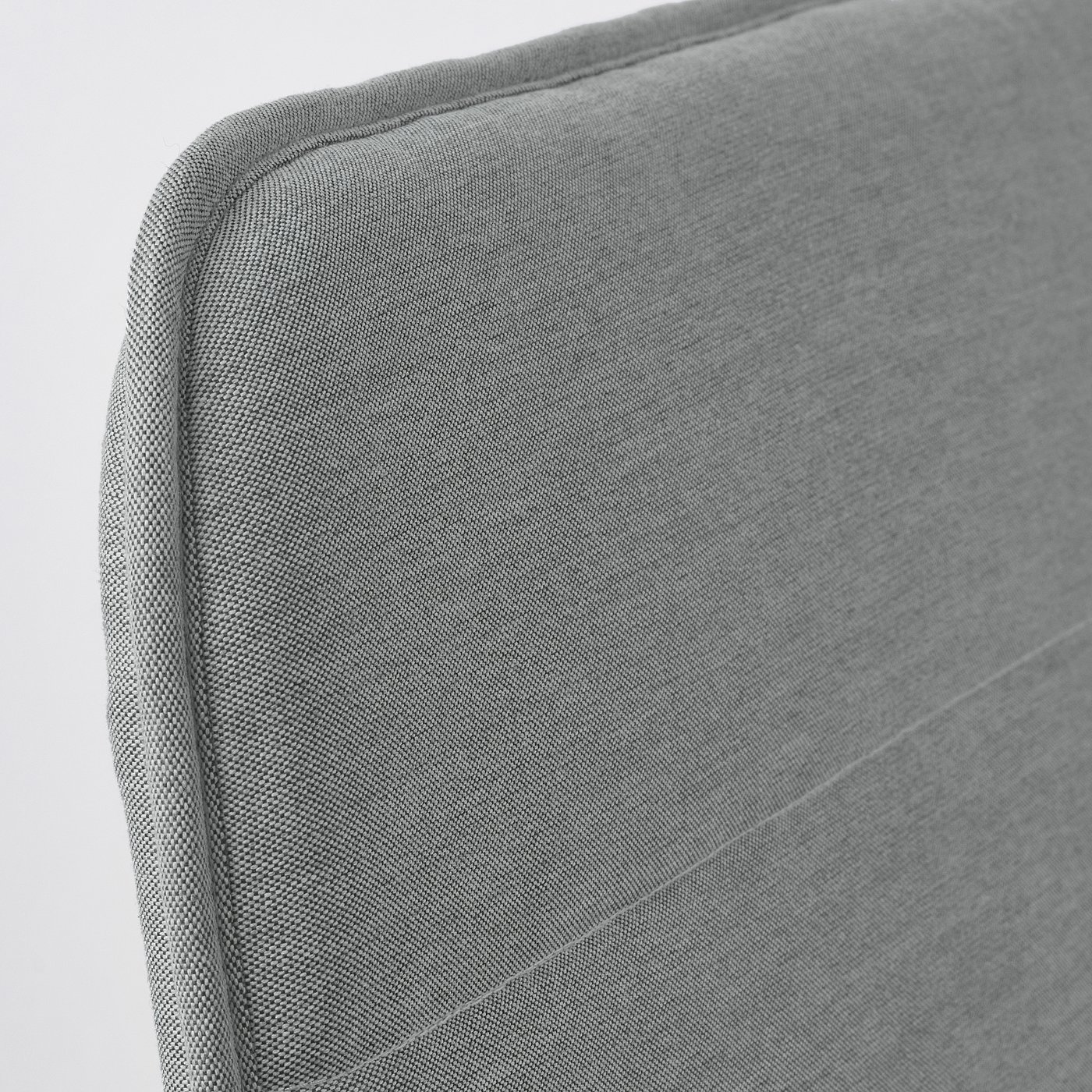 A close-up of a grey upholstered chair, showcasing its well-crafted, smooth fabric and sturdy stitching.