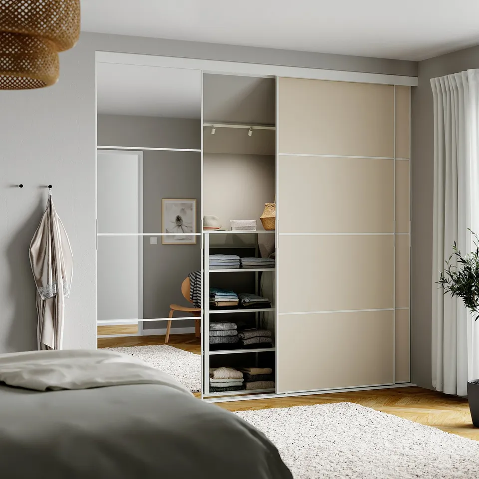 Bedroom with SKYTTA wardrobes, bed, white bedding, window with curtains.