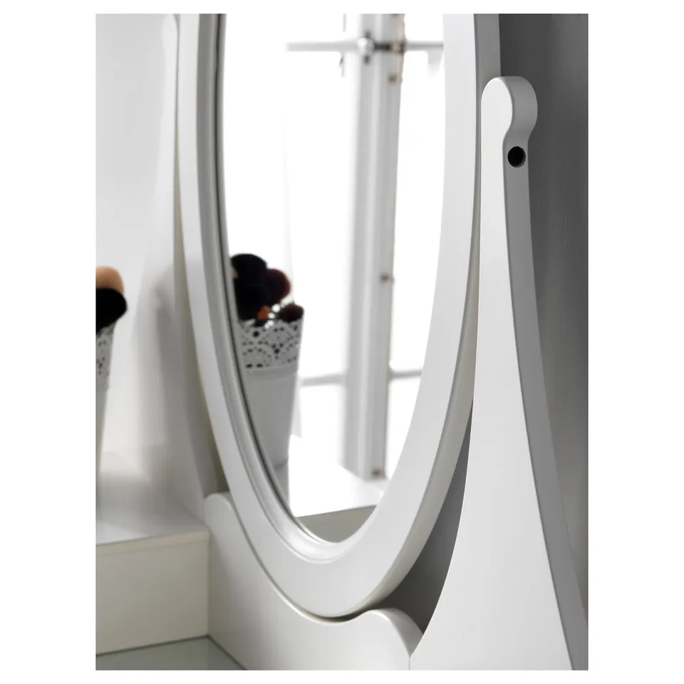 An oval mirror attached to a wall with an adjustable arm, offering versatility for various angles.