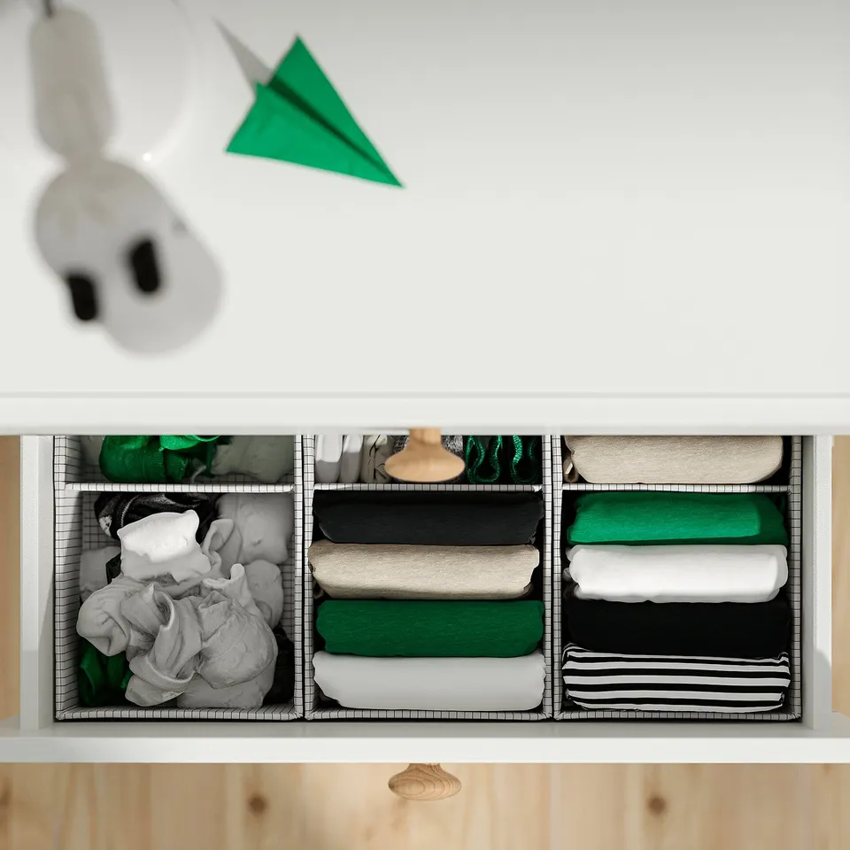 Drawer units with organised clothes in grey, green, black. Adjustable compartments for easy access.