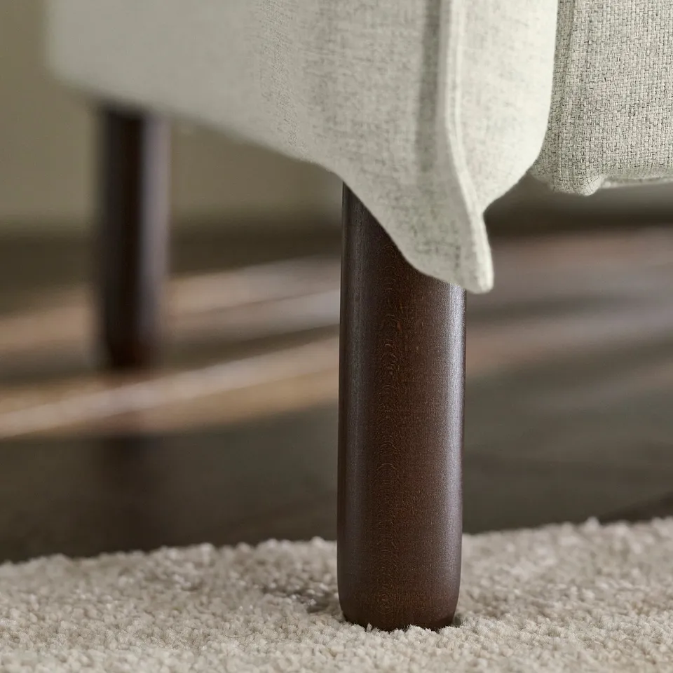 Close-up of modern sofa leg, sleek dark finish, sturdy, stylish design.