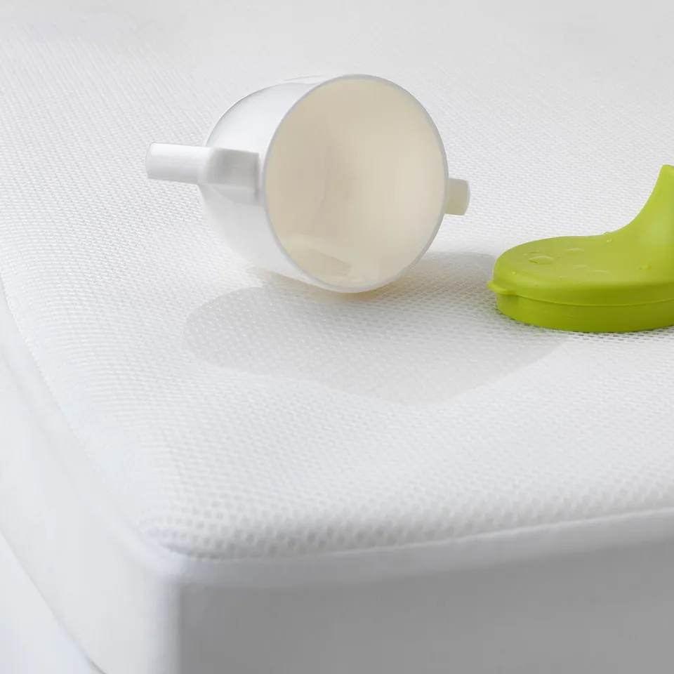 White mattress protector, empty cup, babys lid. Keeps bed clean, dry.
