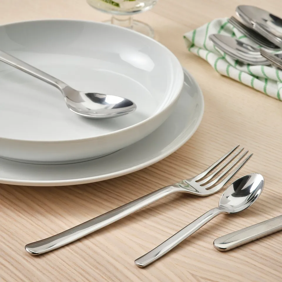 Stainless steel fork, spoon on plates. IKEA 365+ cutlery.