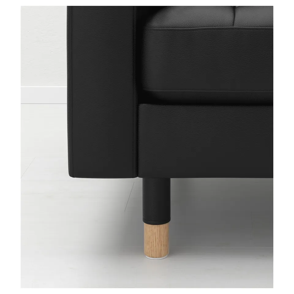 Black leather sofa with wooden legs, showcasing high-quality craftsmanship.