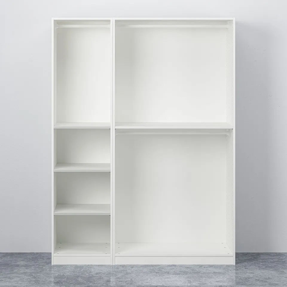 White PAX wardrobe with adjustable feet, closed doors, and empty shelves against a grey wall and floor.