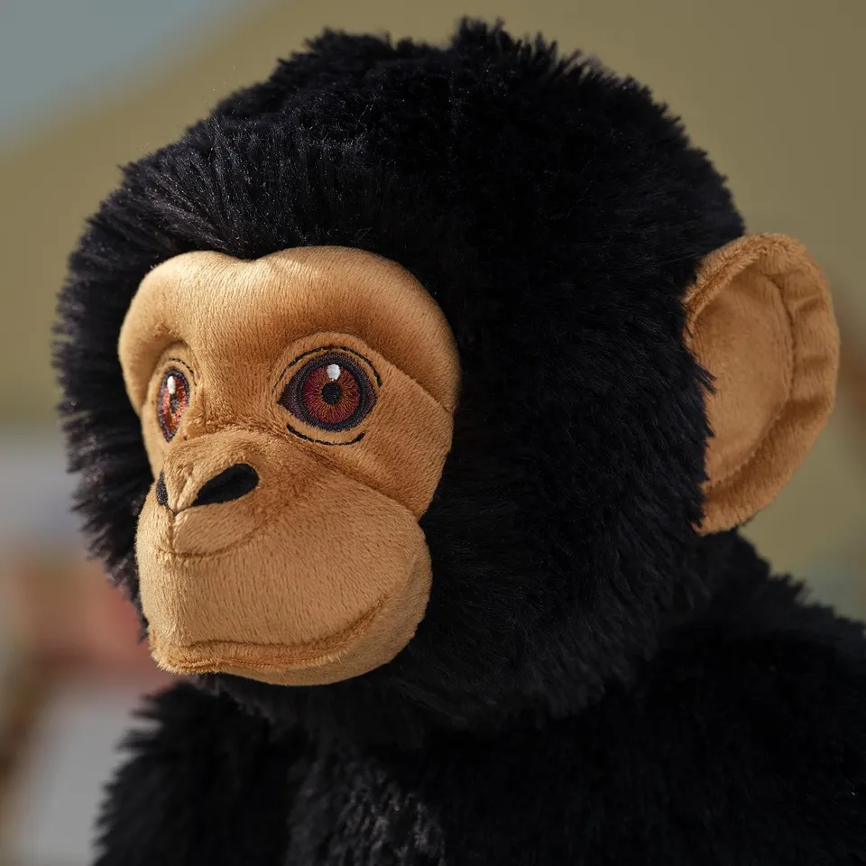 Stuffed toy gorilla with soft black fur, brown face, and detailed eyes, high-quality craftsmanship.