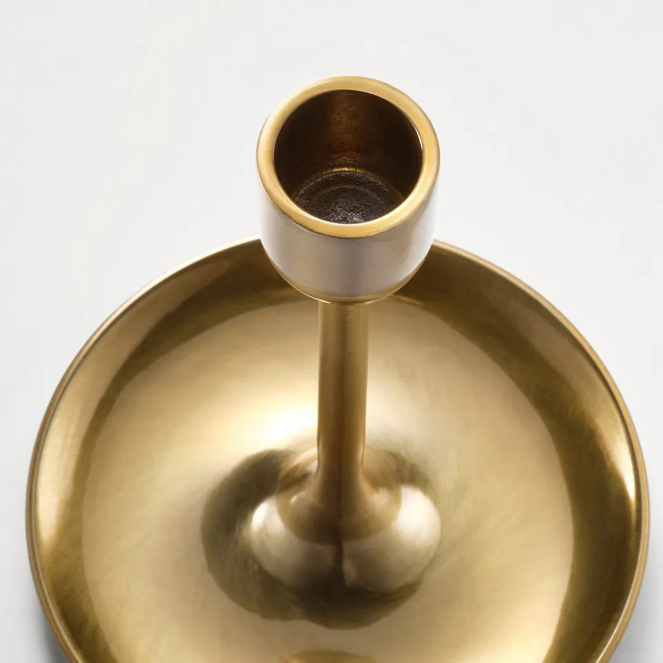 Golden candelabra with three holders, sleek and timeless design. Reflects light, creating a warm, inviting atmosphere.