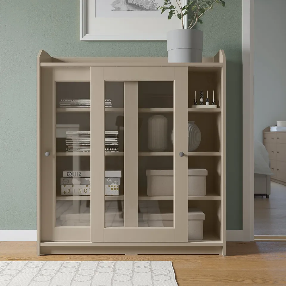 HAUGA light beige cabinet with glass doors, wood finish, rectangular shape & top shelf display.