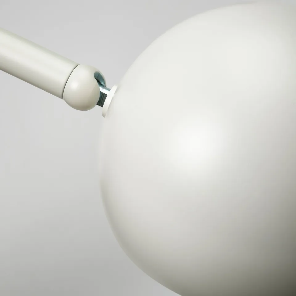 Modern lamp with white curved shade and silver base. The shade is tilted for focused lighting.