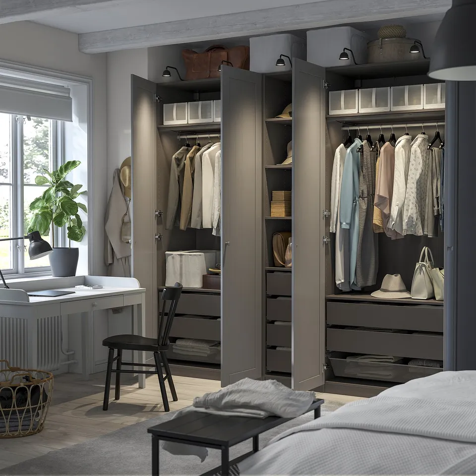 Open wardrobe with organised clothes, shelves, and drawers, lit by integrated lighting.