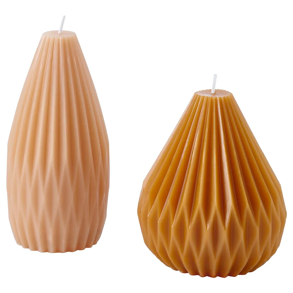 Two stylish candles, one light orange, the other dark. Both teardrop-shaped with pleated design, made of plant-based wax.