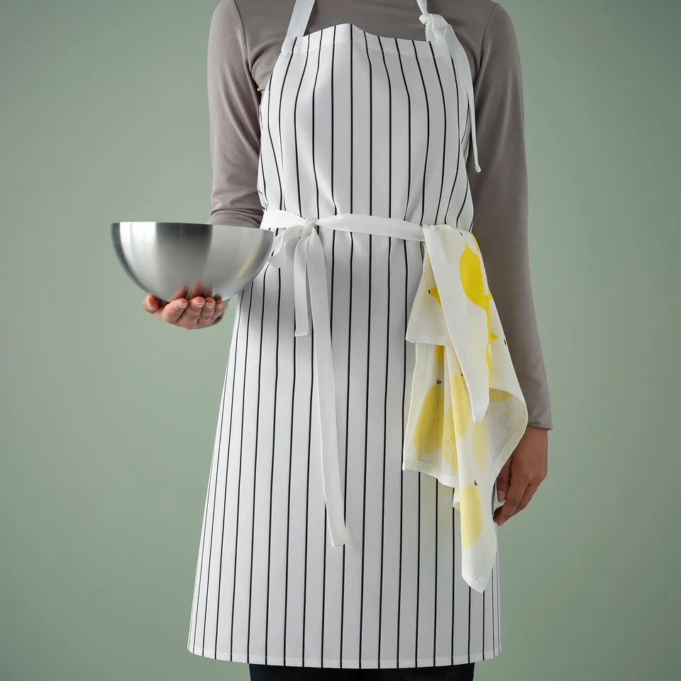 Person in striped apron holding bowl, illustrates kitchen protection and easy cleaning.