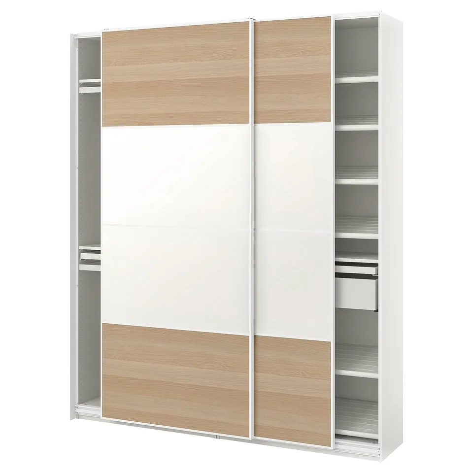 This image an IKEA PAX wardrobe in white with light wood accents. It has sliding doors and multiple shelves for storage.