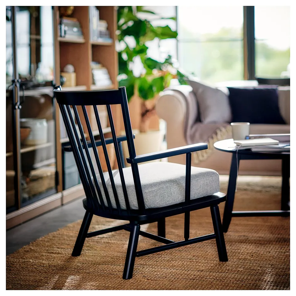Black PERSBOL spindle armchair with grey cushion in cosy living room.