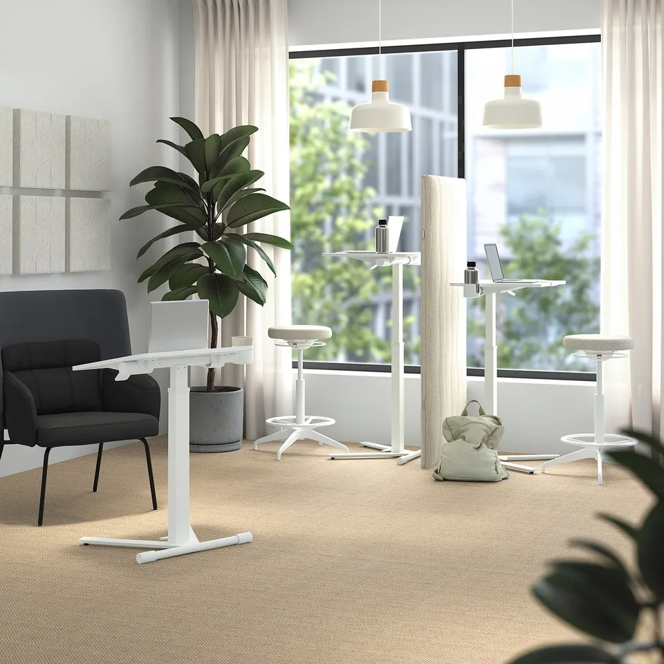 MITTZON laptop table near window, adjustable for sitting/standing. White, contrasts with dark grey chair. Adjusts 70-115 cm.
