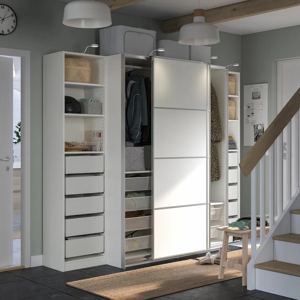 White PAX wardrobe under stairs with lights.