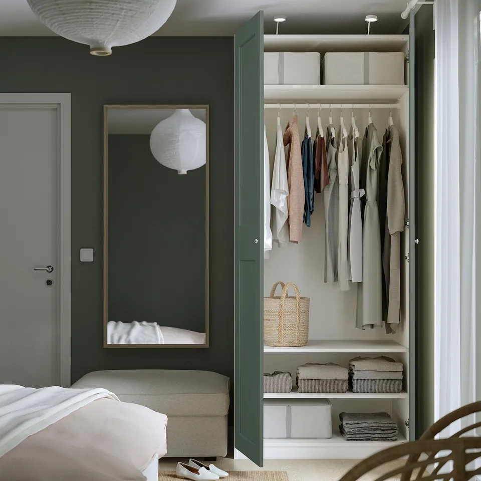 Close with clothes hangers, shelves, baskets, bed, mirror.