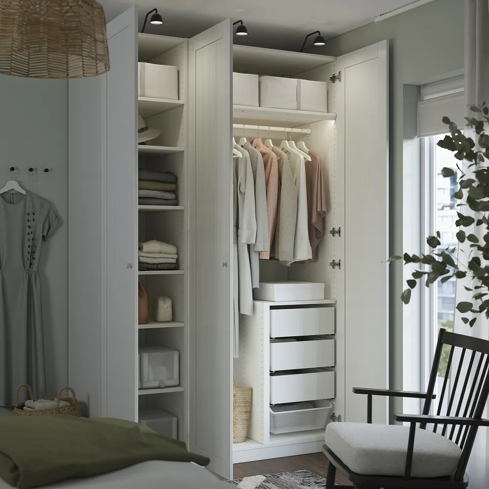 Closed wardrobe with shelves, hanging space, boxes, and drawers. Integrated lighting illuminates organised clothes and accessories.