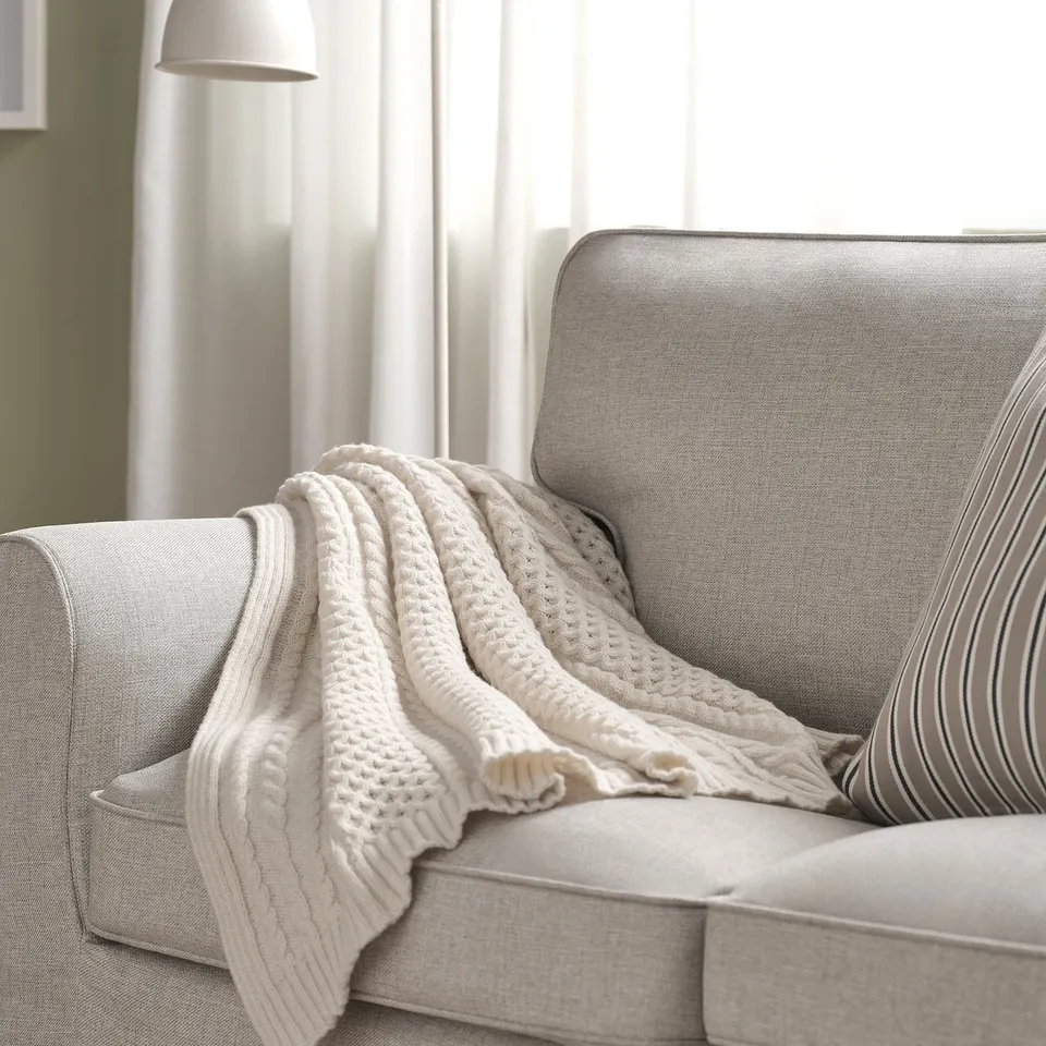 SÖRBYSKOGEN: cosy cream throw blanket on light grey sofa, fits perfectly, soft polyester.