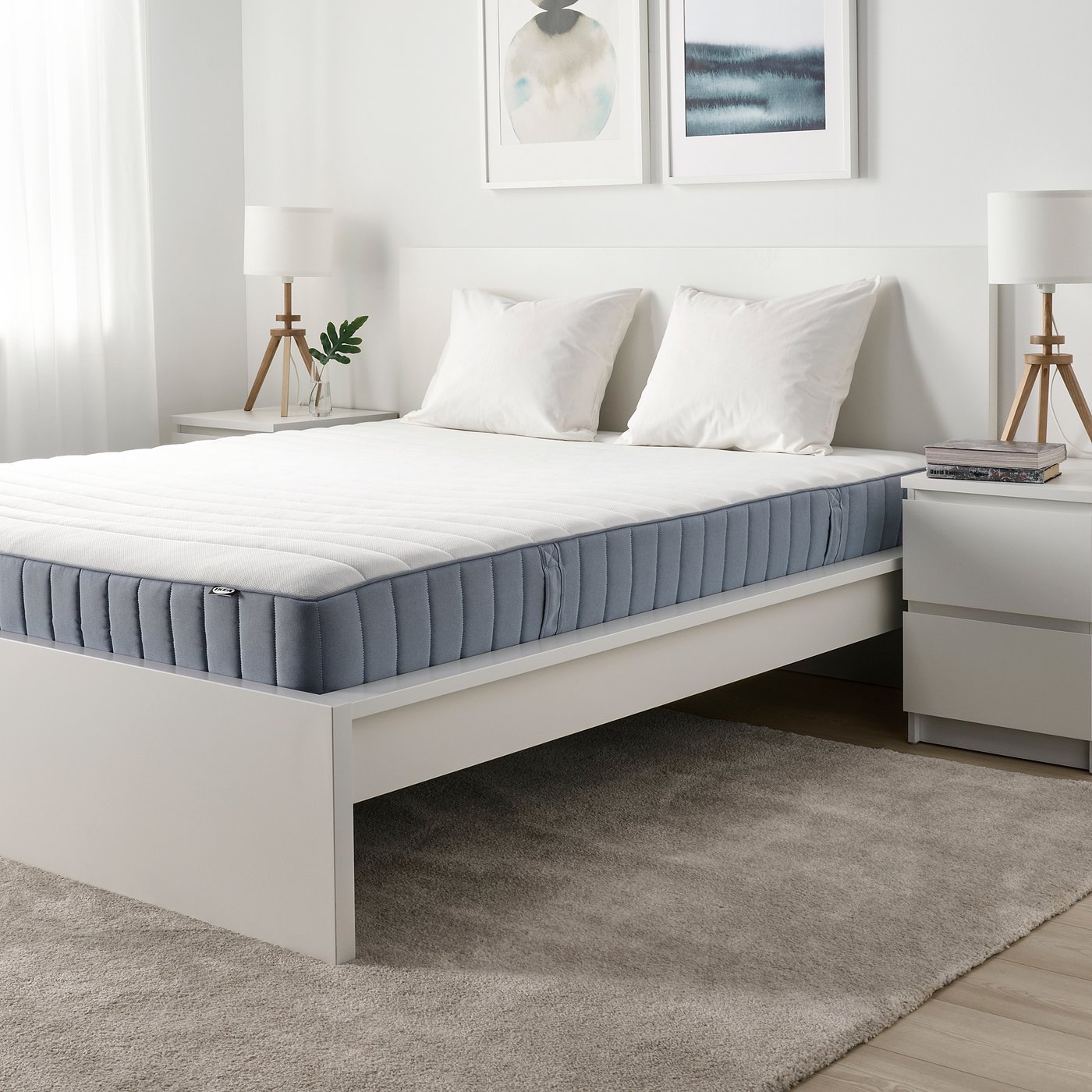 Minimalist bedroom with white IKEA VALEVÅG mattress on low platform bed, gray-blue, and neutral decor.