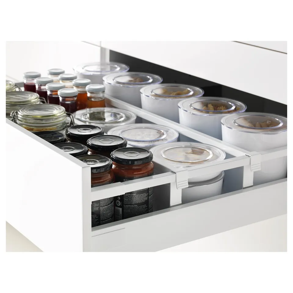 White kitchen drawers holding various jars, organised neatly. Part of the METOD system with full-extension functionality.