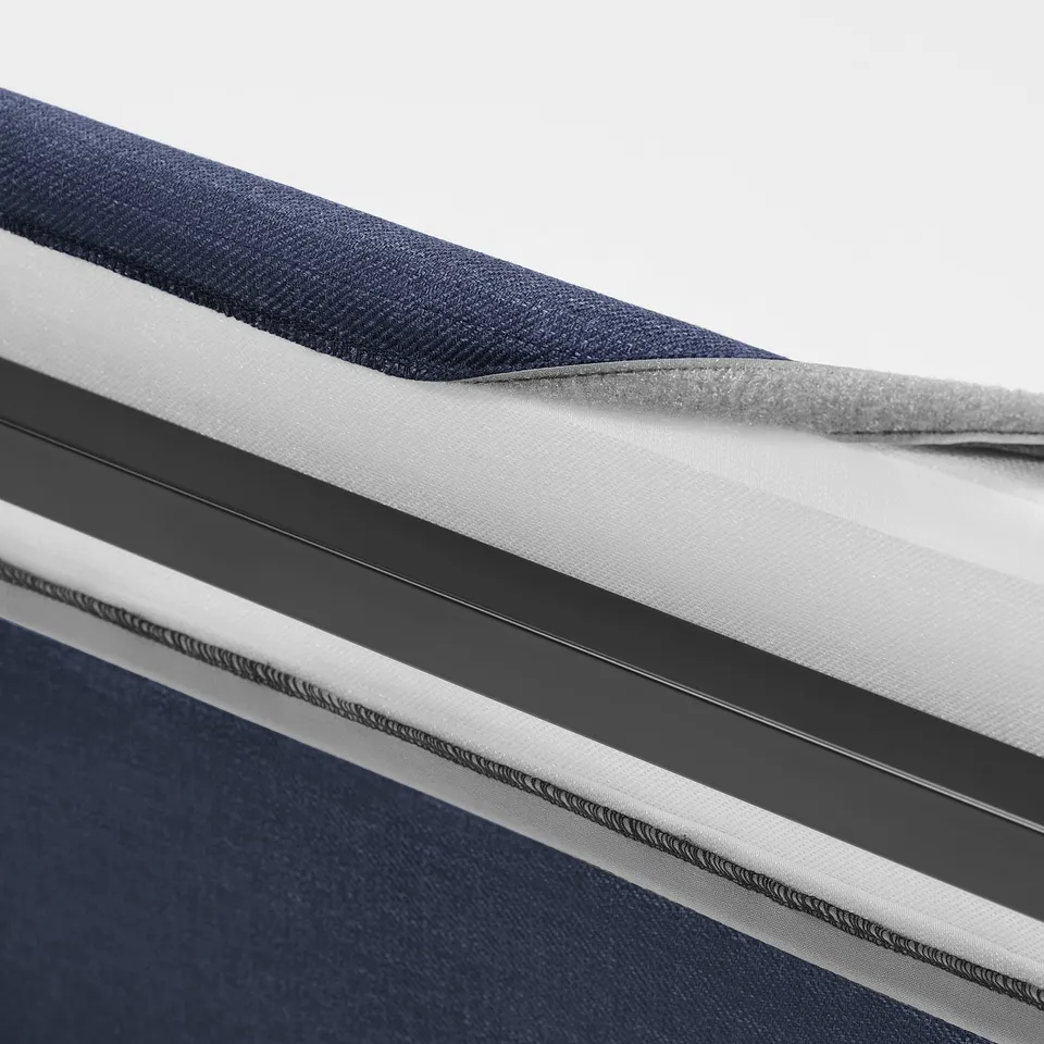 Close-up of upholstered bed frame with padded headboard. Removable, machine-washable cover with piped edges.