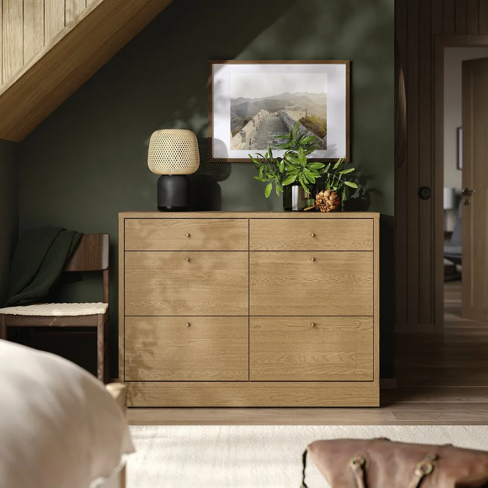 TONSTAD wooden dresser; six drawers, light wood finish, narrow for bedroom. Topped with framed photo, lamp, and plant.