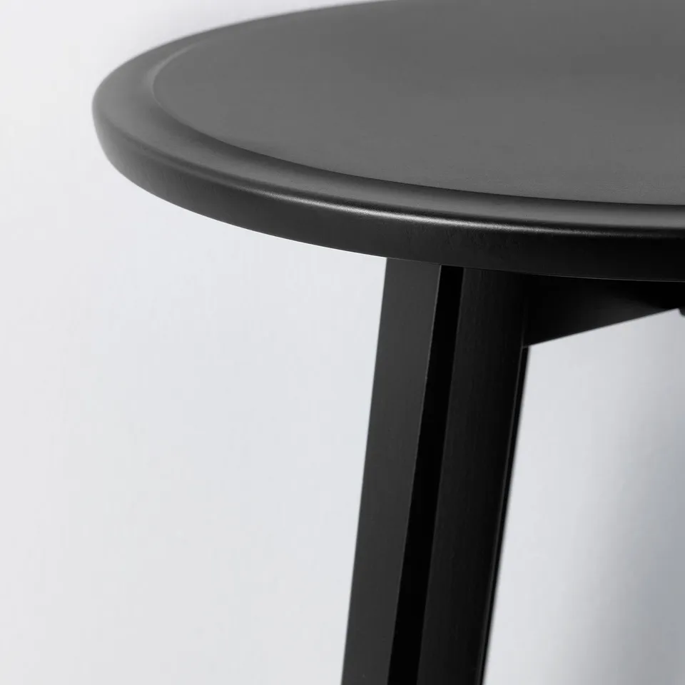Stylecrafted KRAGSTA table edge; smooth black surface, rounded shape, slim metal support.