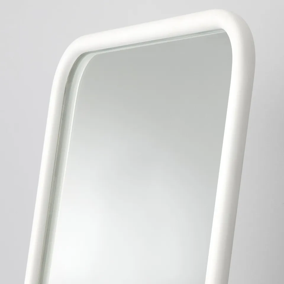 Rectangular mirror, sleek white frame, smooth edges, reflection clear, wall-mounted.