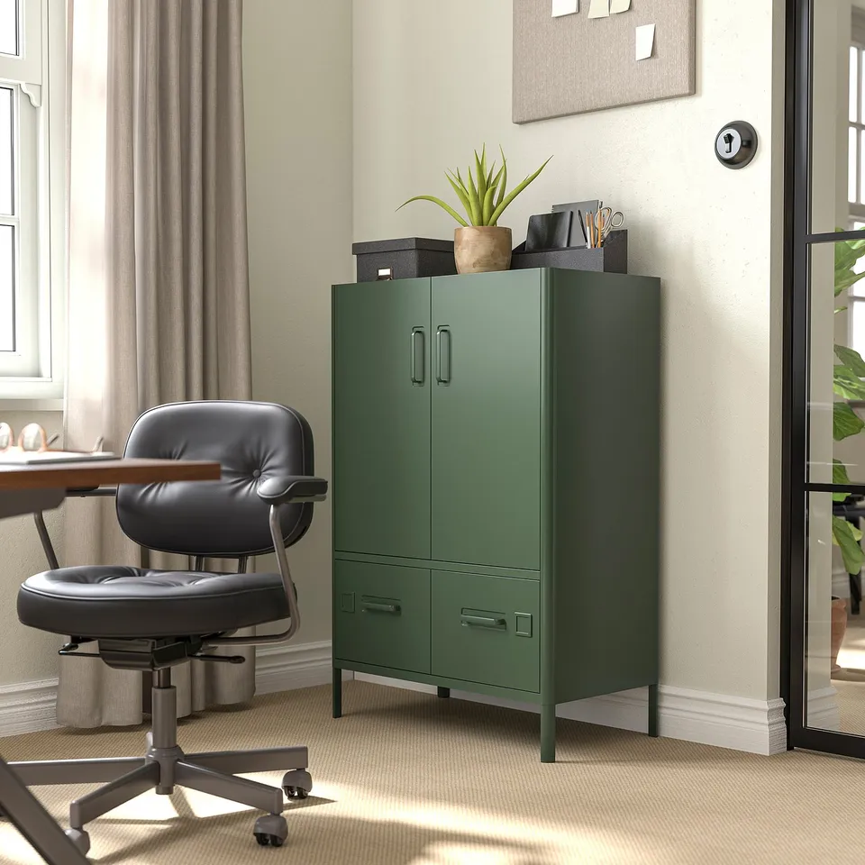 Home office with IDÅSEN green cabinet, leather chair, desk by window. Cabinet stores supplies, chair and desk near window.