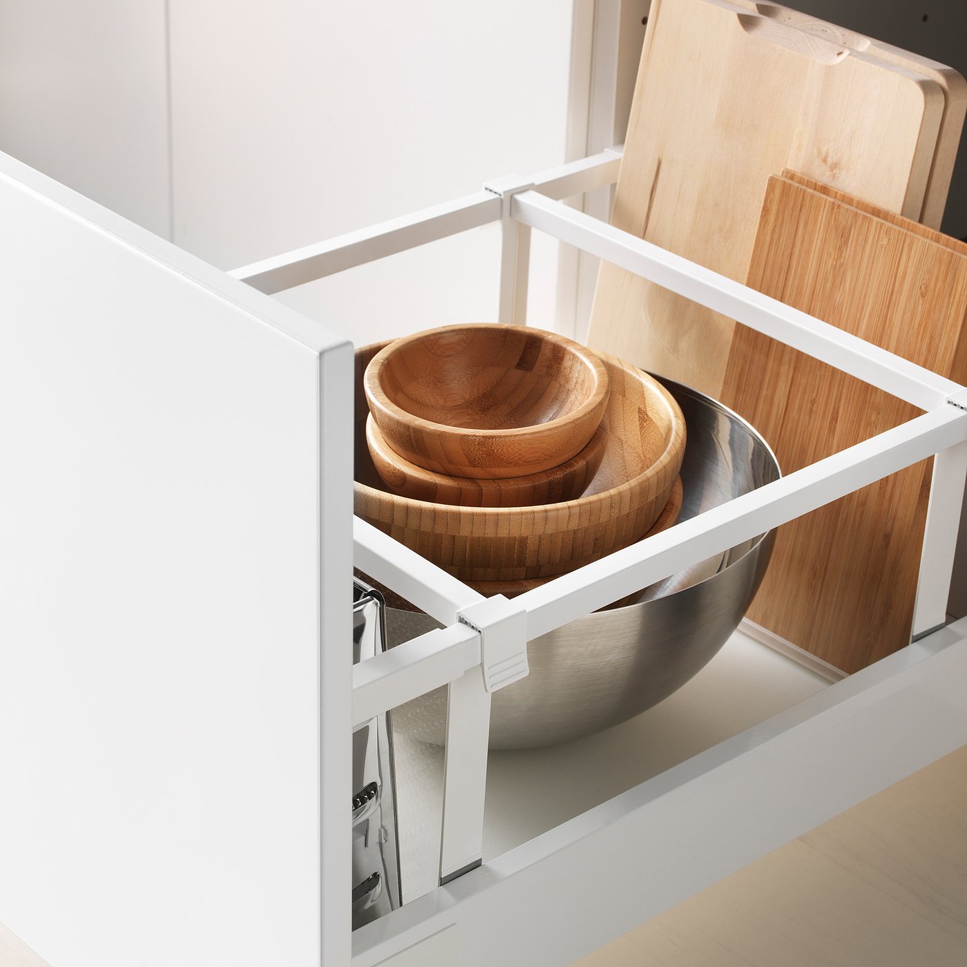Open kitchen drawer with wooden bowls and metal bowl, showcasing sturdy, smooth-running design.