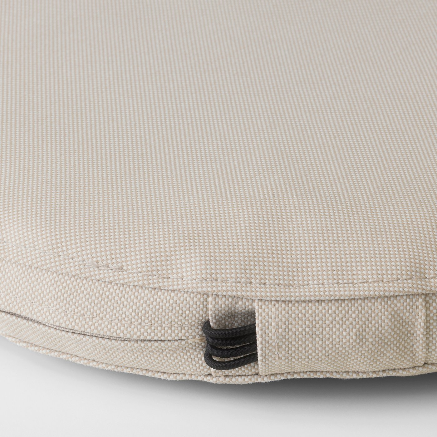 Close-up of durable, textured outdoor cushion, featuring elastic strap for secure attachment.