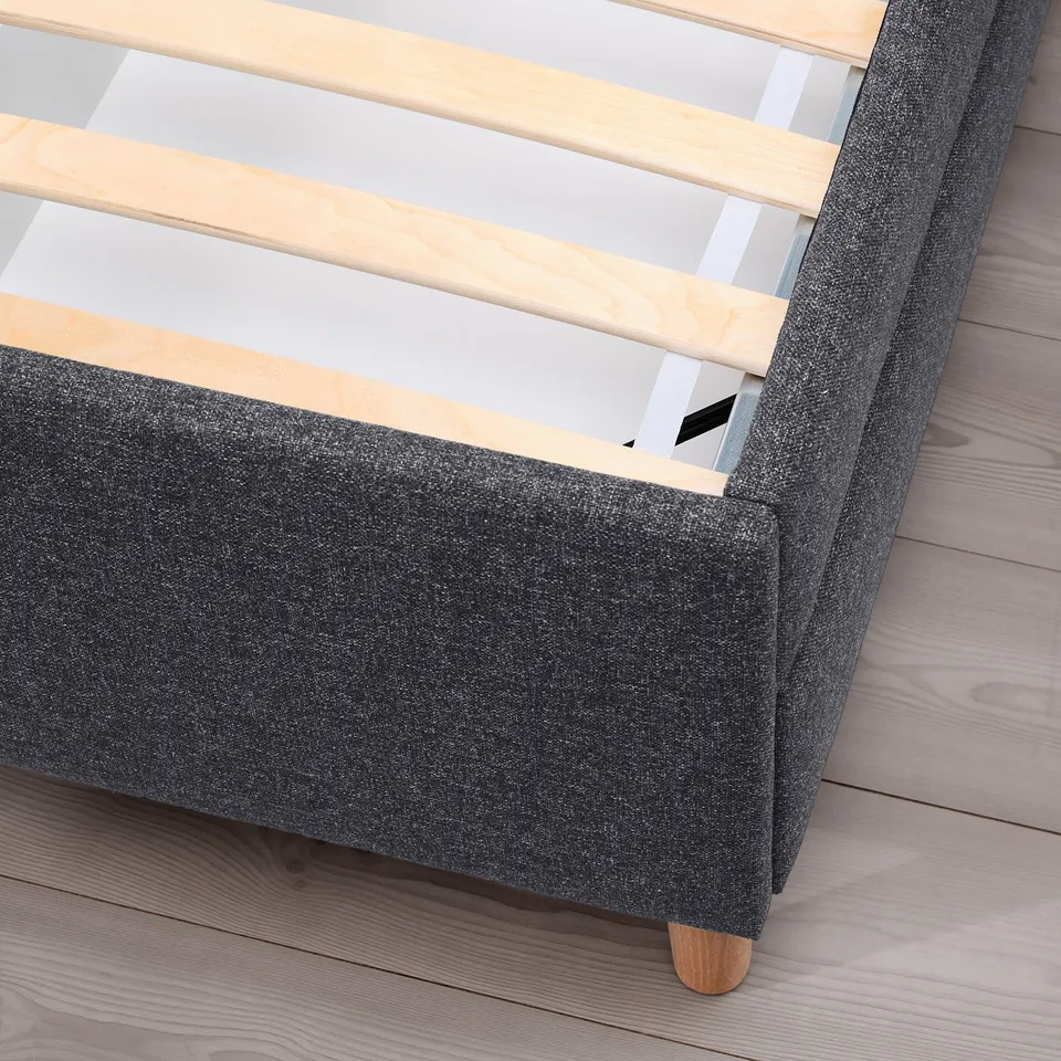 Bed frame with upholstered headboard, wooden slats, and drawers.