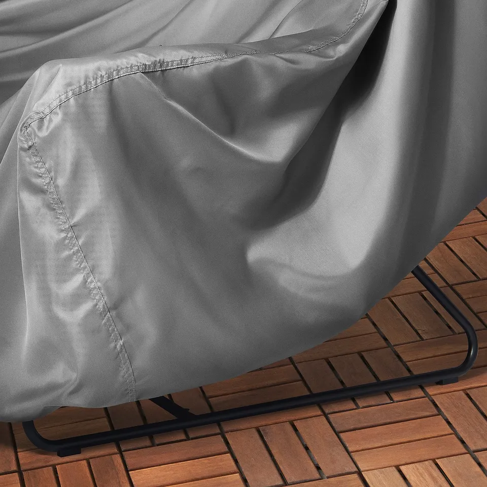 Water-repellent patio furniture cover, securely fitted with elastic, ensuring protection against elements.