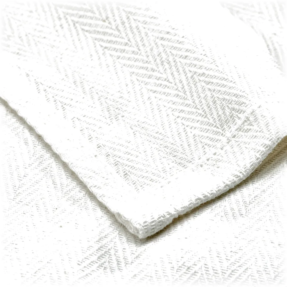 Folded stack of white cotton towels with herringbone weave, neatly displayed.