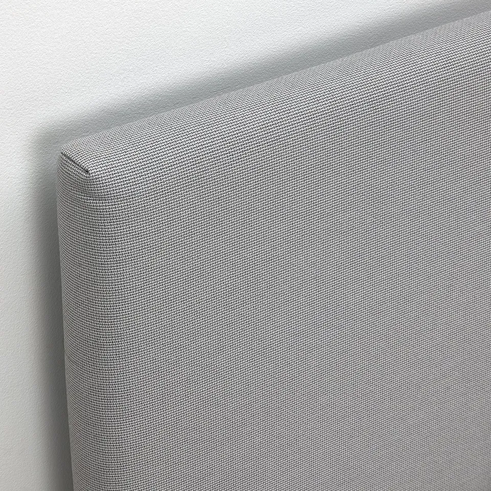 Closeup of GLADSTAD beds padded headboard, showcasing its textured, modern design with quality fabric.