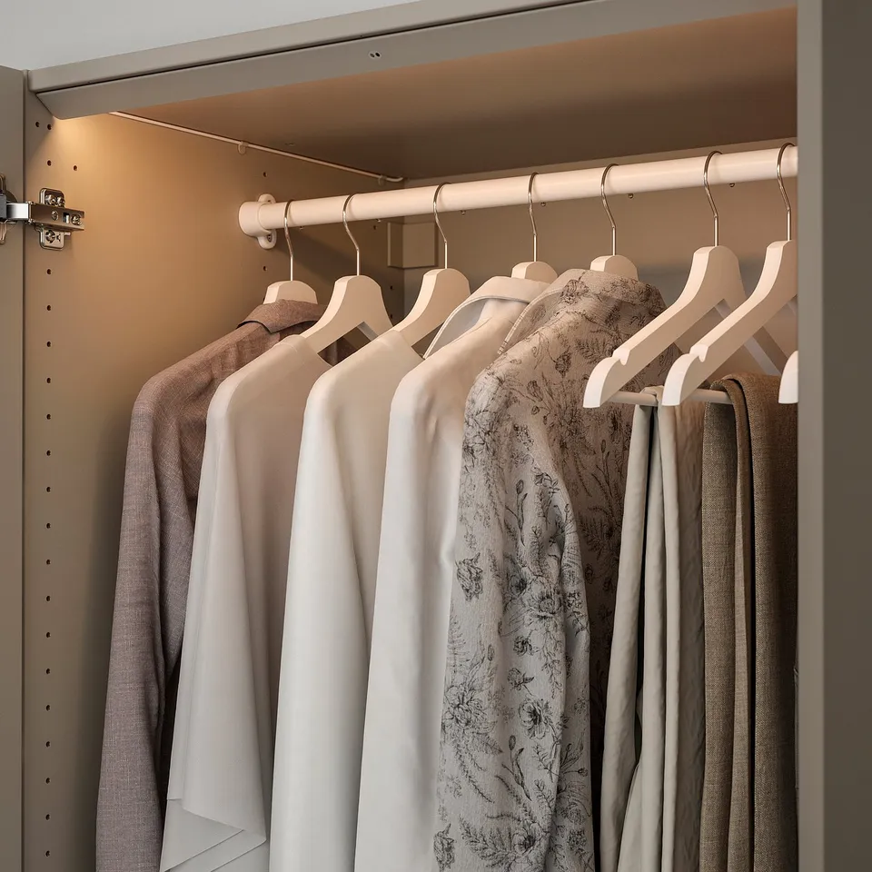 A modern wardrobe with led light strips illuminating clothes on hangers.