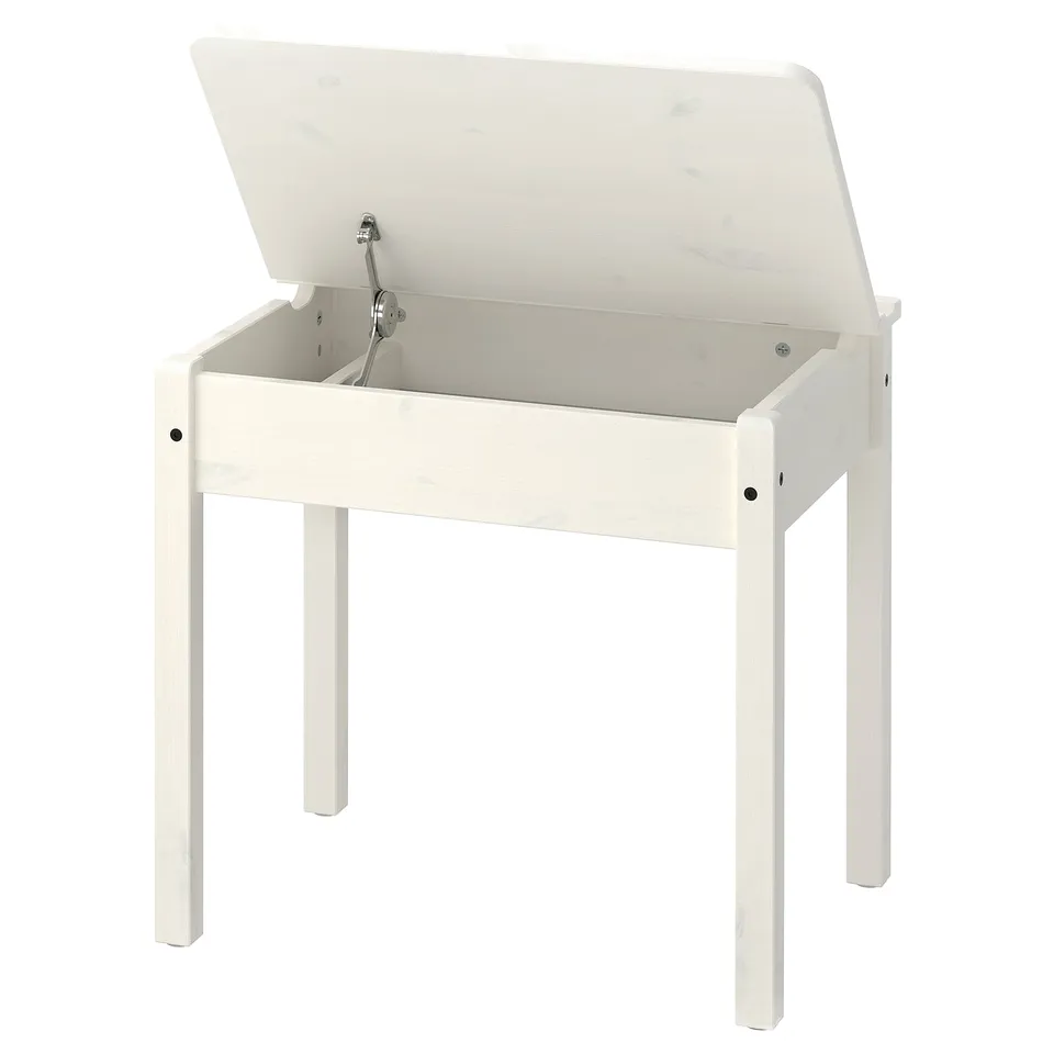A white childrens desk, SUNDVIK, with a lift-up top for storage. Its made of wood and has a rectangular shape with rounded corners.