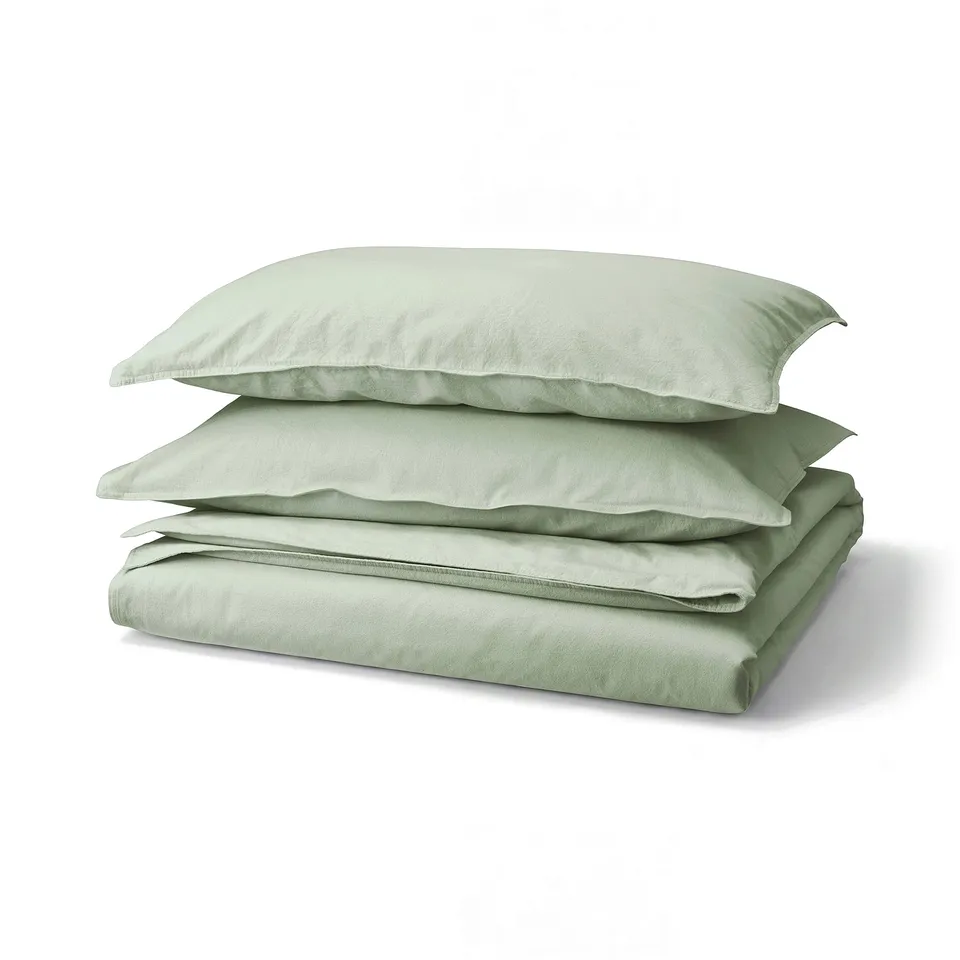 Light green, folded bedding set with two pillows and flat sheet, smooth fabric.
