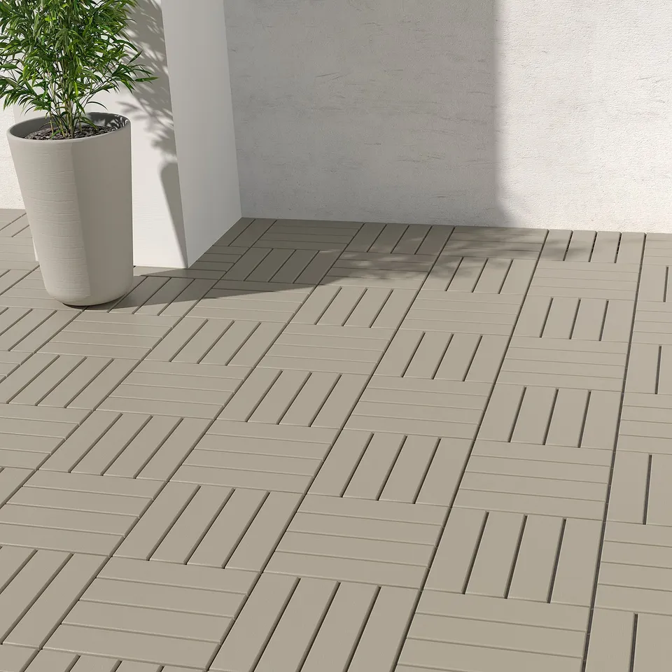 Balcony with beige herringbone decking, plant in corner.