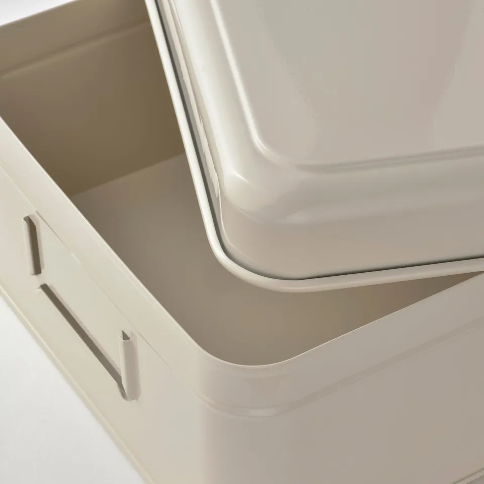 Stacked cream-colored metal storage boxes with sleek handles and sturdy edges.