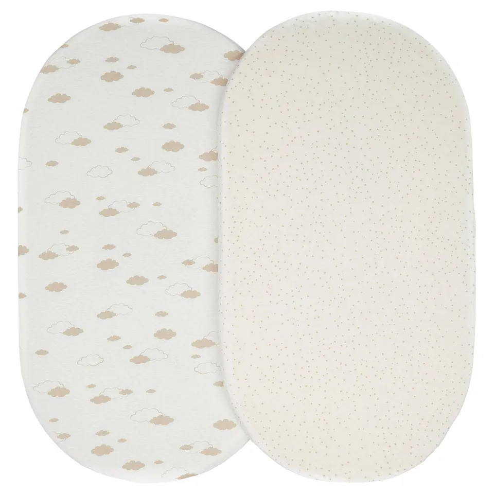 Two light-colored oval-shaped baby crib sheets. One has a dotted pattern, the other has a cloud design. Both are made of 100% cotton.