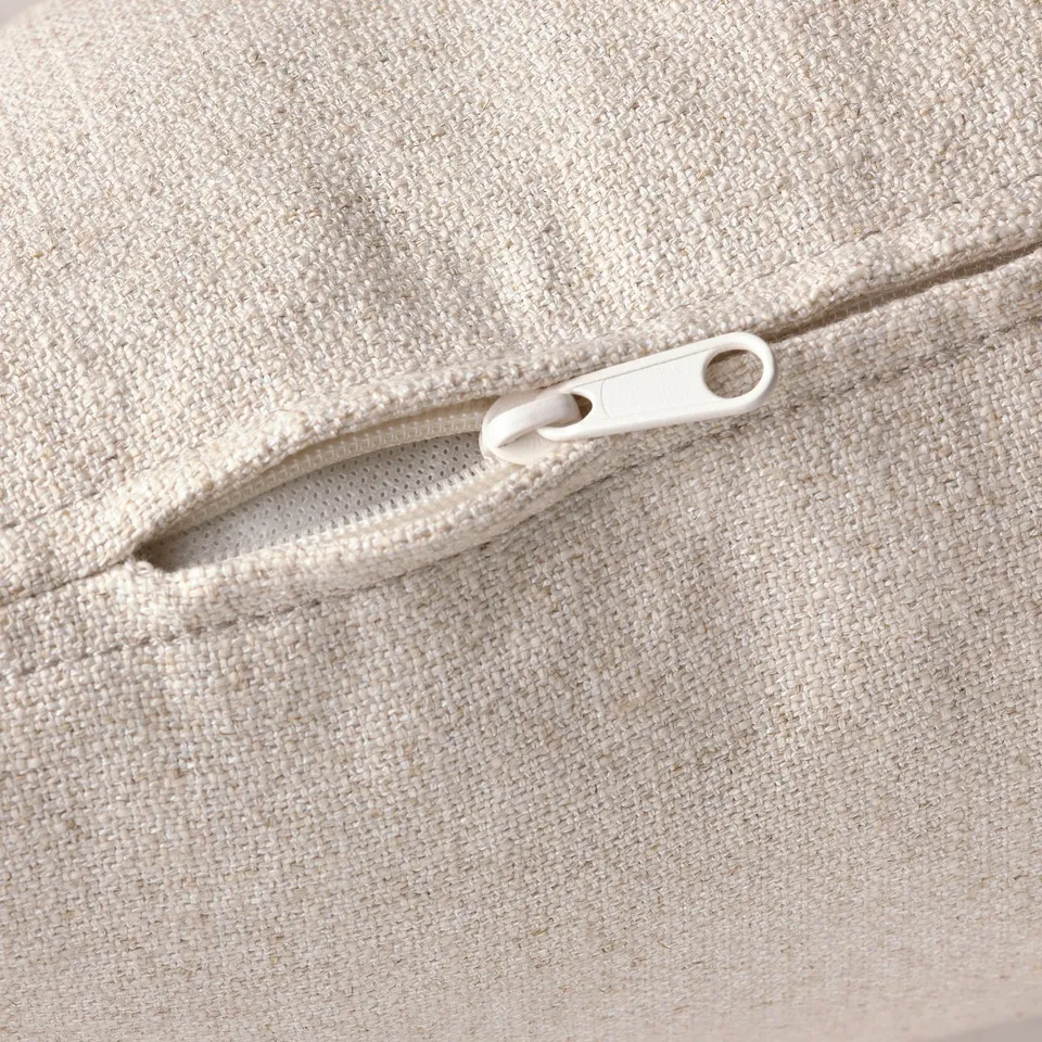 Close-up of a high-quality beige fabric zip on a chaise lounge, showcasing sturdy pull and precise stitching.
