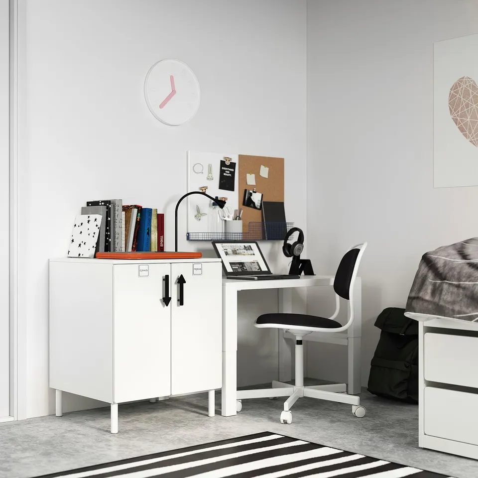 Small home office with white desk, chair, and cabinet; minimalist design.