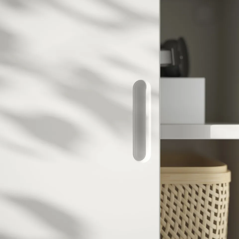 A white TONSTAD tv bench with a sleek handle and woven basket storage.