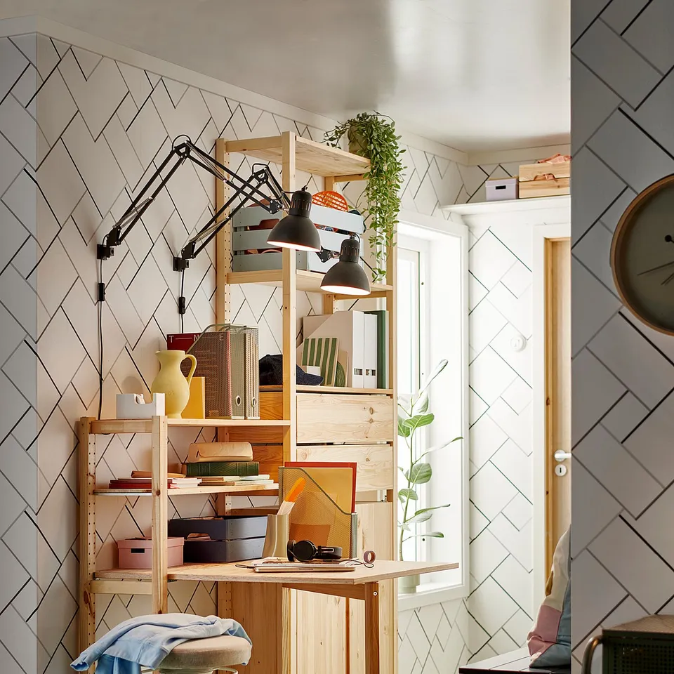 Home office featuring IVAR natural pine desk and shelves. Wooden, with adjustable lamps, colourful accessories, and plants.