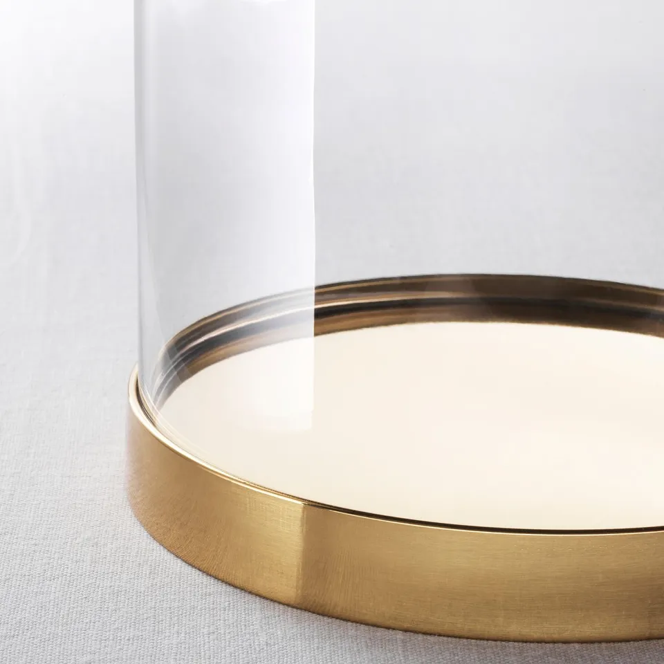 Gold-rimmed glass dome on light surface, showcasing high-quality, elegant design.